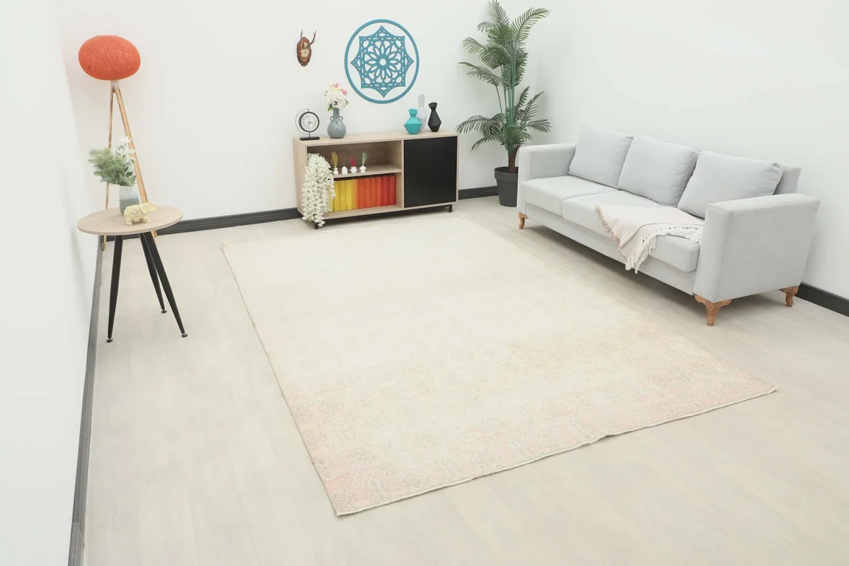 Large vintage cream and rose floral rug displayed in a modern living room setting.
