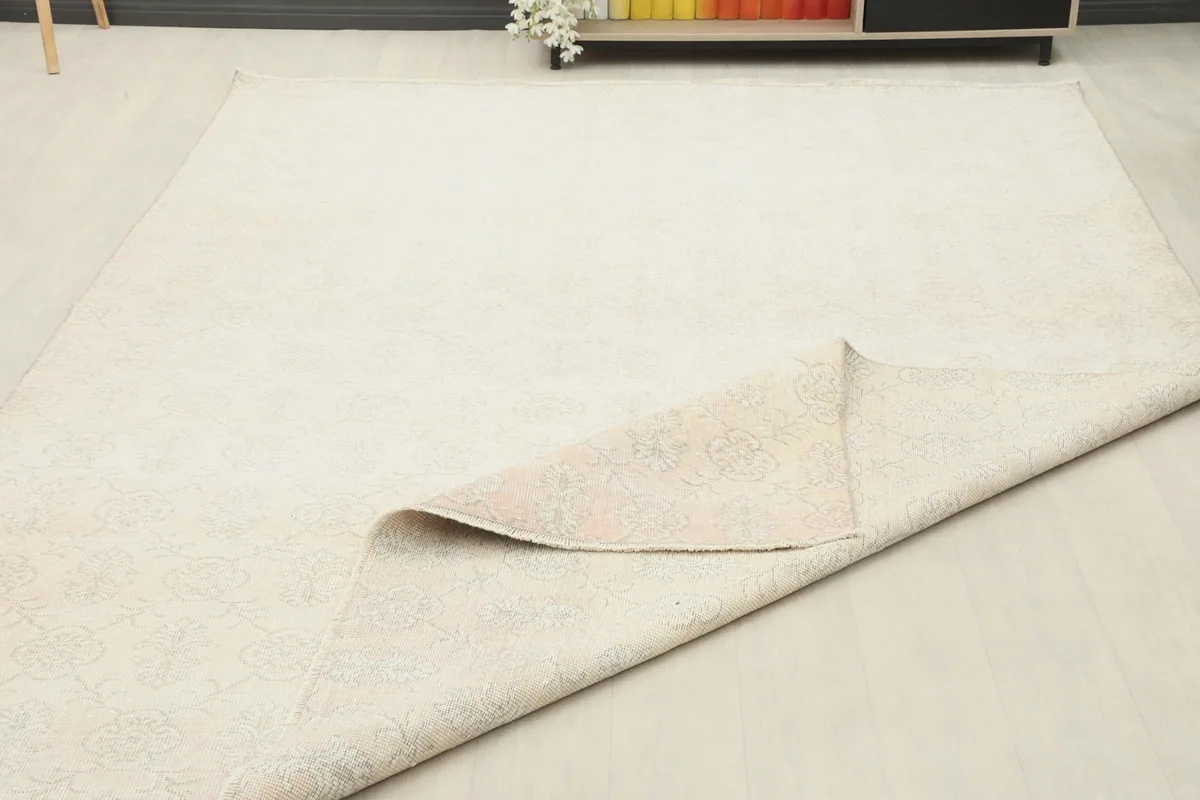 The rug laid out in a room with a corner folded over, showing its flexibility and backing.
