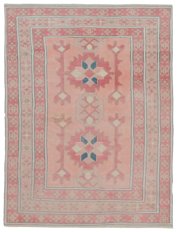 Full overhead view of the 4'11" x 7'1" vintage pink geometric Anatolian rug on a white background