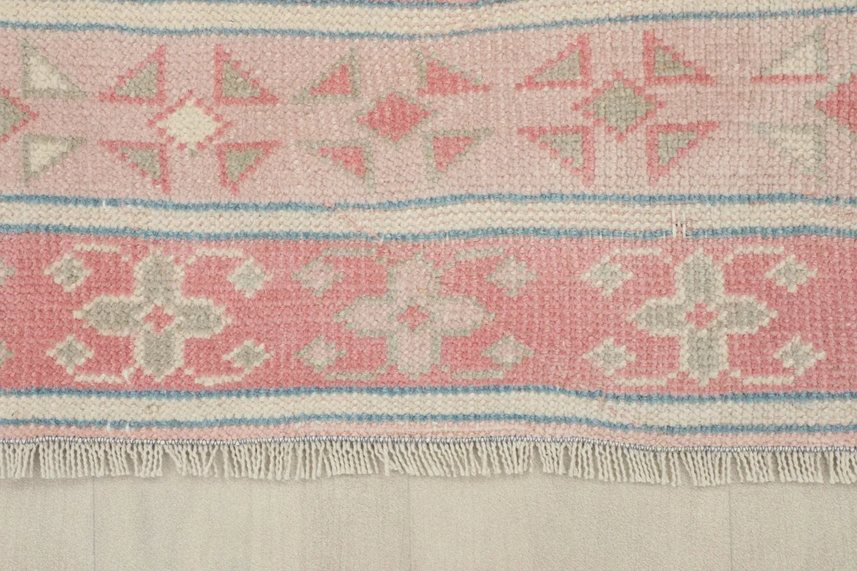 View of the short, natural fringes and patterned border of the hand-knotted rug