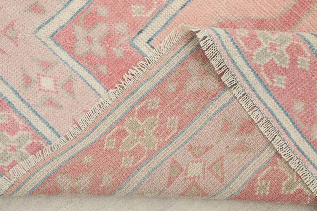 Corner of the rug folded back to show the cotton foundation and construction
