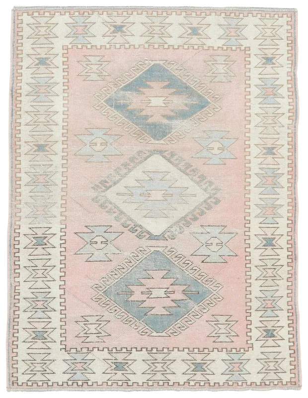 Full overhead view of the pink and blue vintage Anatolian rug on a white background