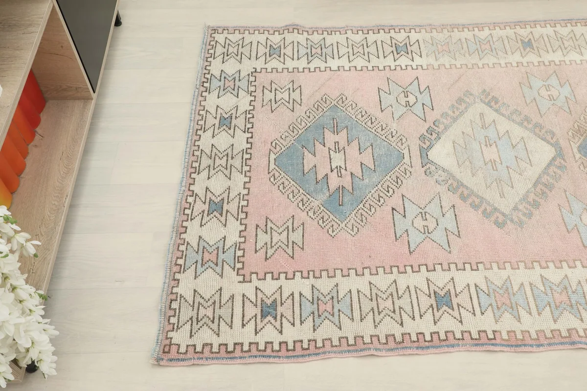 Angled view from the side, focusing on the border and central geometric designs of the rug