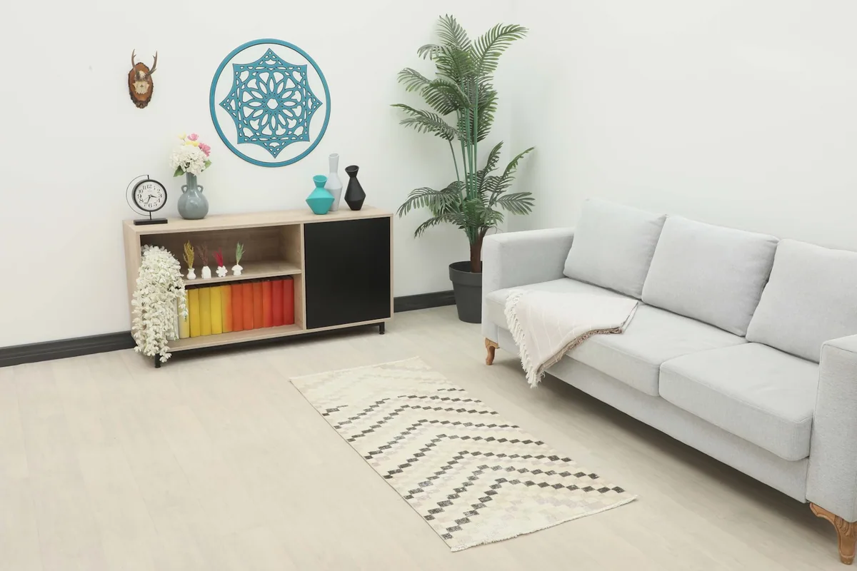 Vintage Anatolian runner rug in an ivory and charcoal geometric pattern placed in a living room setting