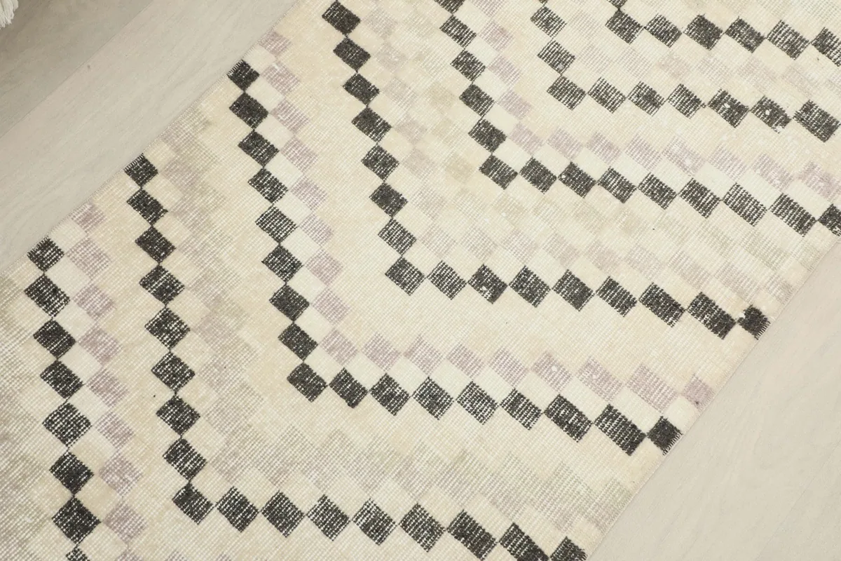 Detailed view of the chevron pattern and color variations in the ivory and charcoal vintage rug