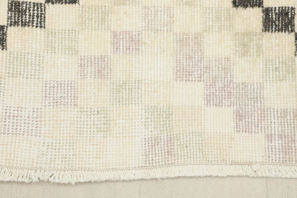 Detail of the short, natural fringe and the cotton foundation of the hand-knotted vintage rug