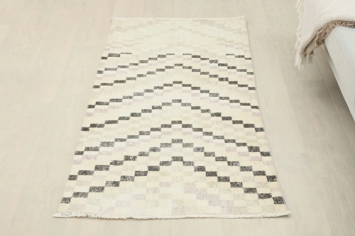 Overhead view of the vintage ivory and charcoal runner rug from a slightly elevated perspective