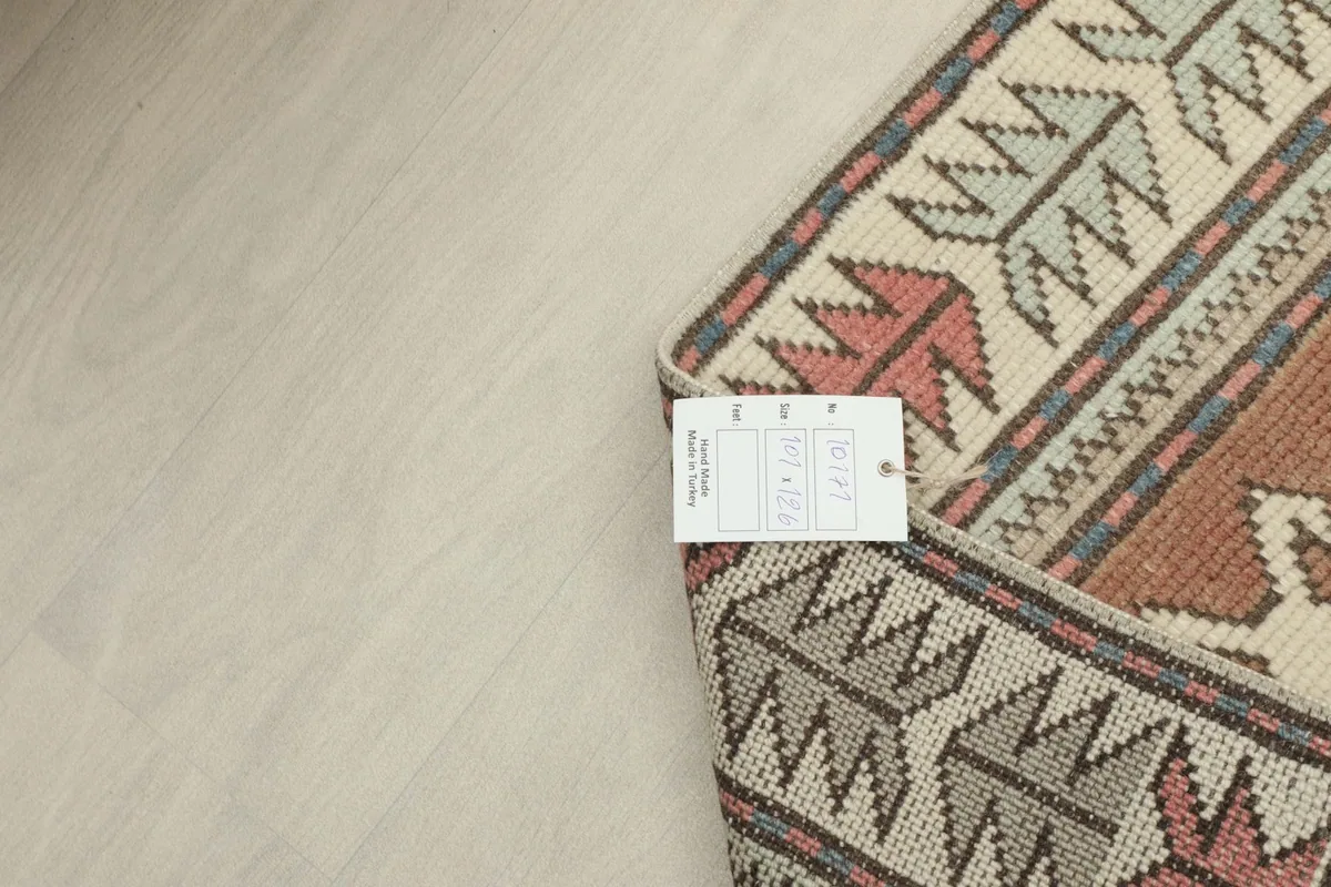 Back of the rug with a tag, showing the intricate hand-knotted cotton foundation
