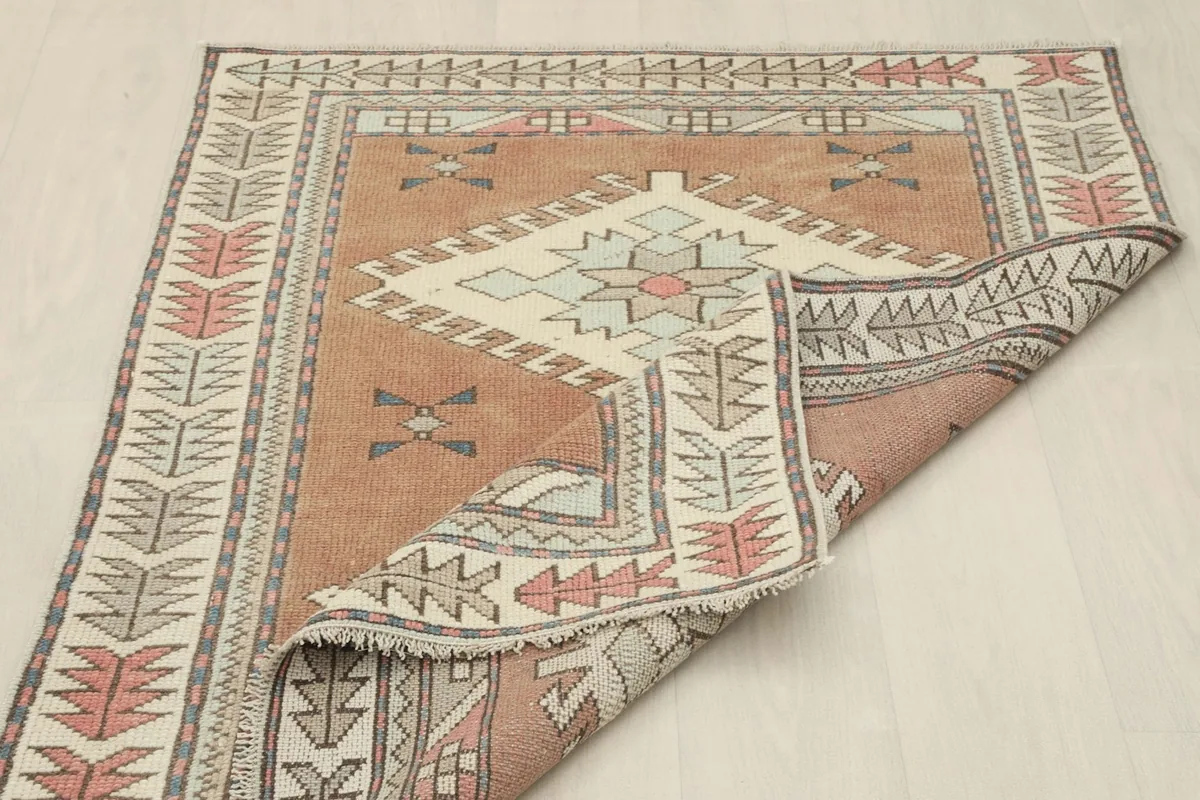 Rug partially folded, revealing the reverse side and the hand-knotted wool pile