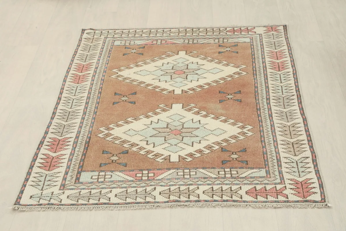 Full overhead view of the rust geometric vintage rug, slightly angled on a light floor