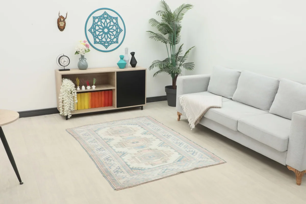Vintage rug displayed in a modern living room setting with a light gray sofa and wooden cabinet.