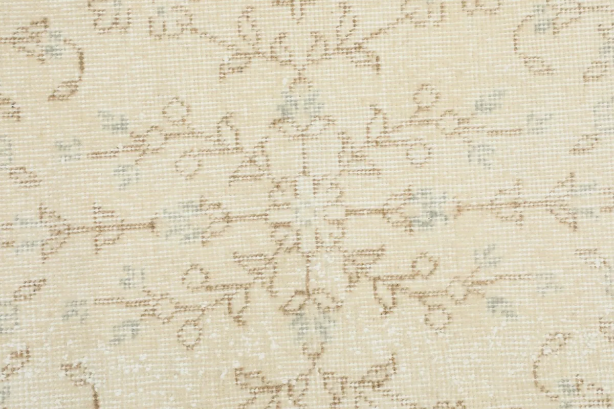 Detailed view of the wool pile and subtle color variations within the floral design of the vintage rug.