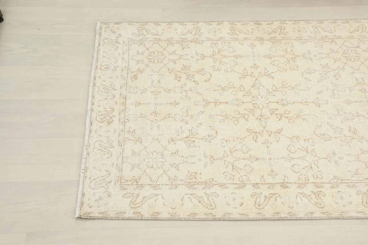Detail of the rug's border and field, revealing the vintage patina and hand-knotted texture.