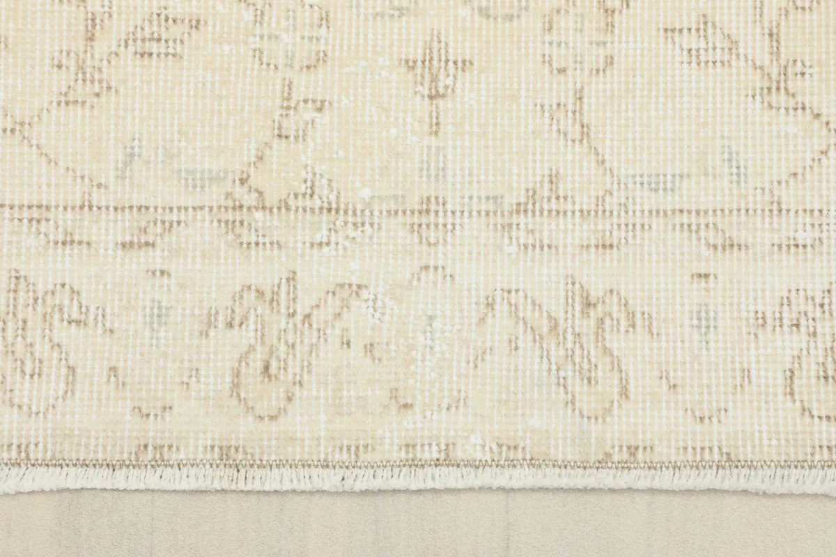 Close-up of the short, natural fringe and the edge of the hand-knotted wool pile rug.