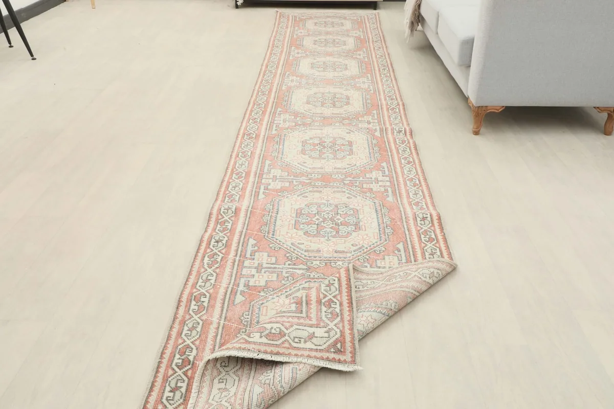 Long view of the runner rug with one end partially folded, demonstrating its length and flexibility