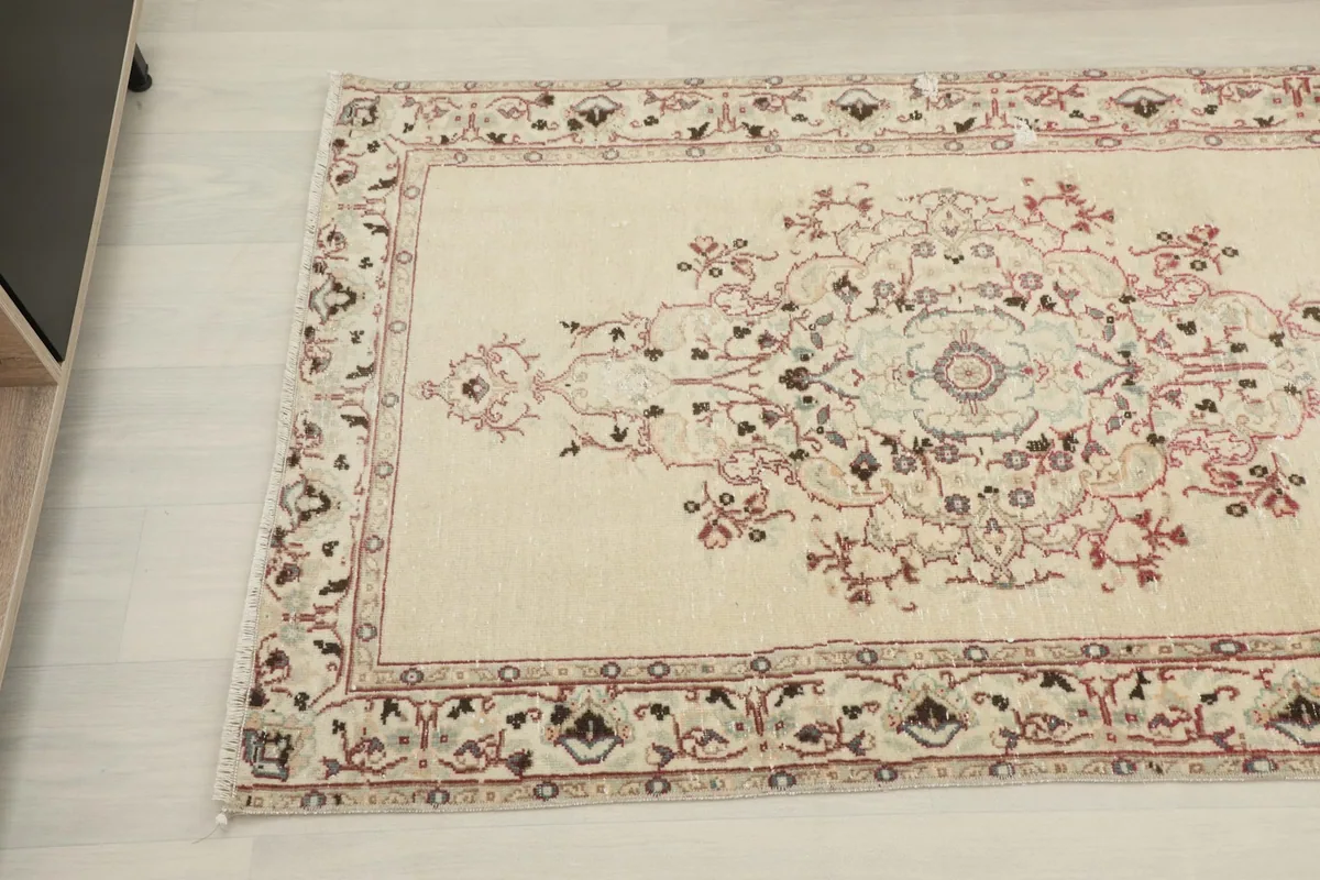 Angled view highlighting the central medallion and floral motifs of the vintage rug