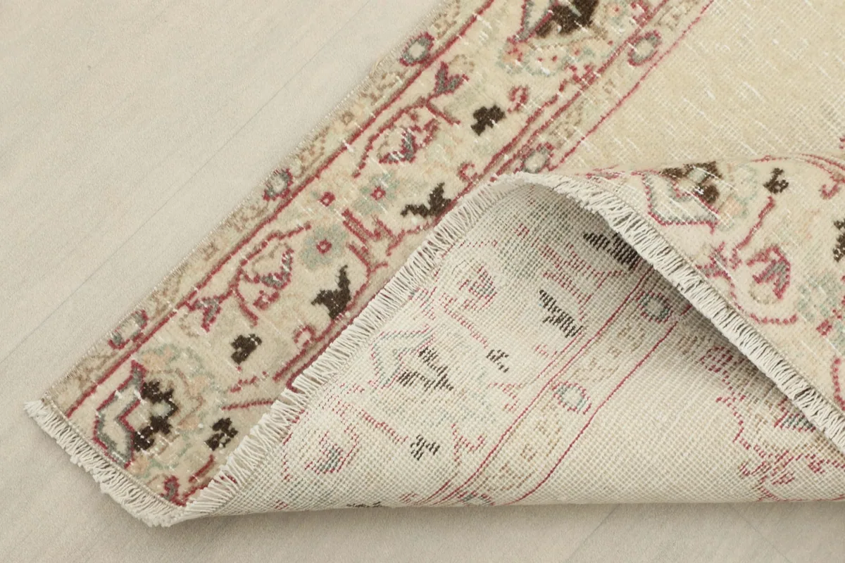 View of the rug's back, showing the hand-knotted cotton foundation and wool pile