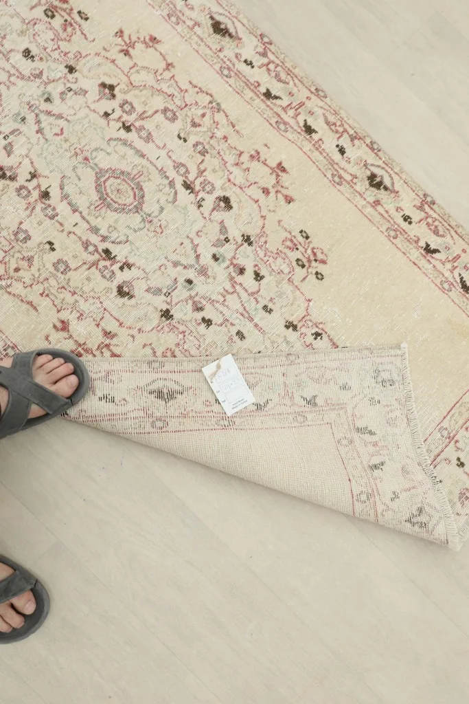 Close-up of the rug's back with a tag, showing the hand-knotted quality and foundation
