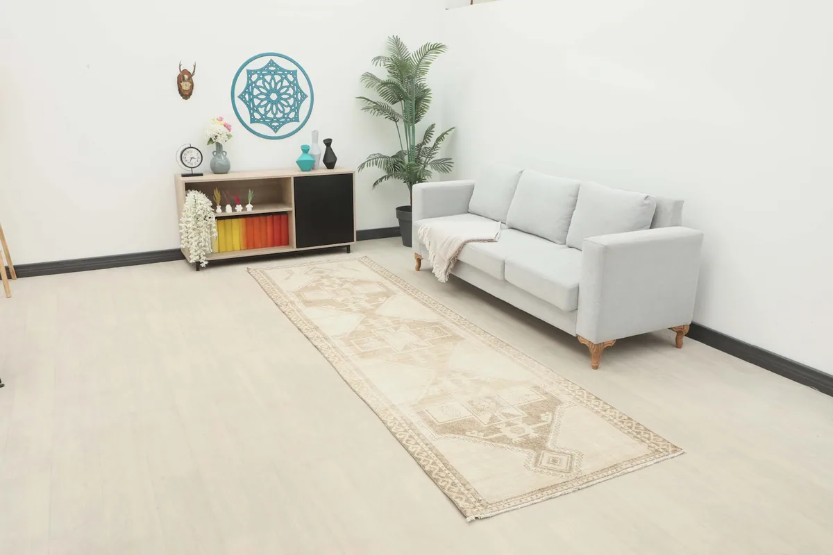 Vintage Anatolian runner rug displayed in a living room setting with a light sofa and decor