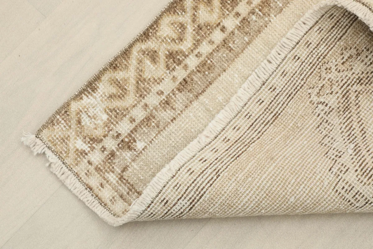 View of the back of the rug, showing the hand-knotted wool pile on a cotton foundation