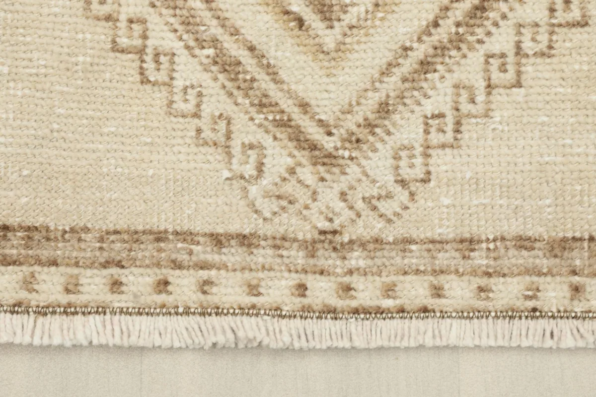 Detail of the short, natural fringes and the end border design of the hand-knotted rug