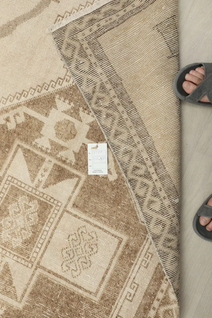 Overhead view of the rug with a size tag and feet for scale, showing the overall pattern