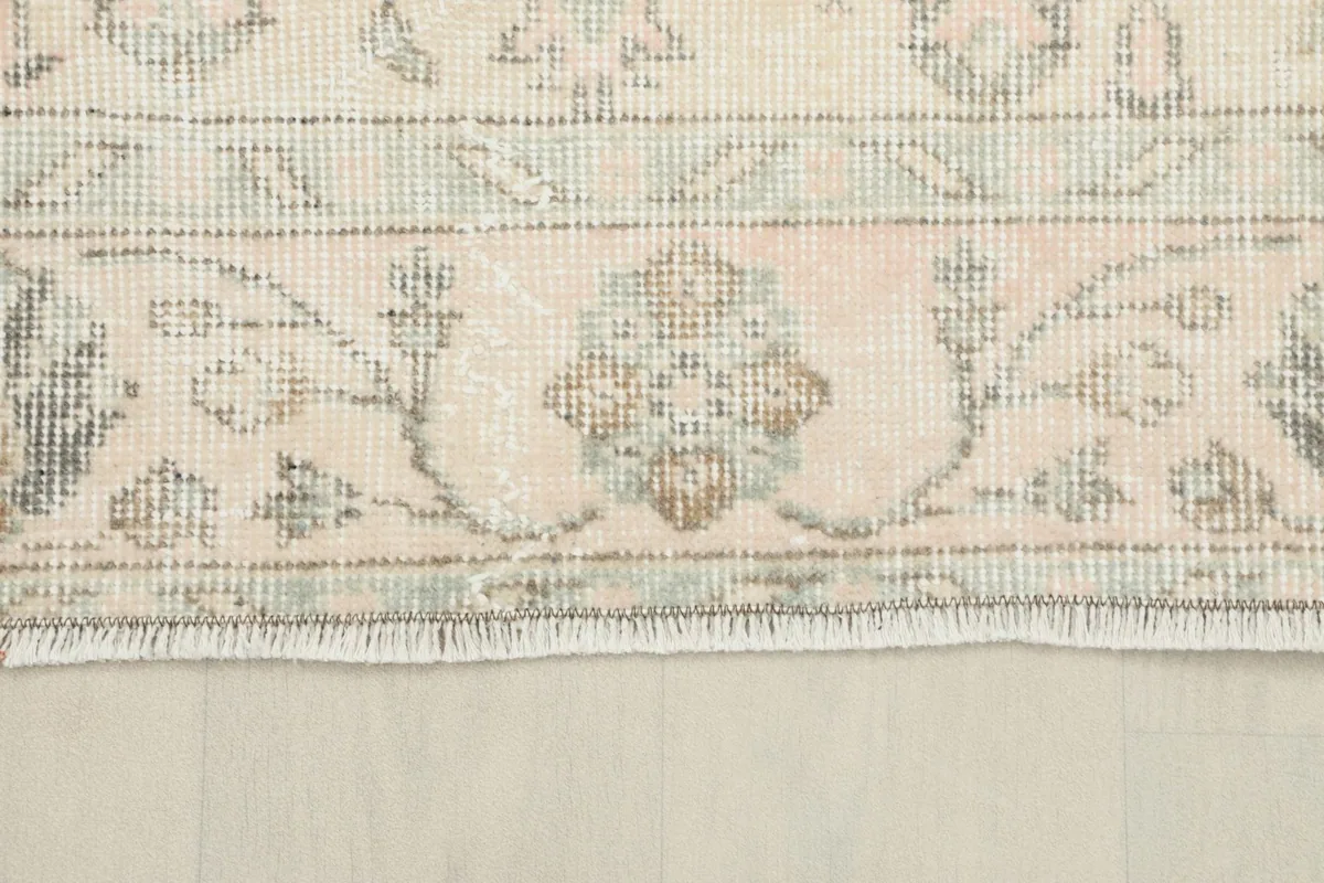 View of the rug's fringe and a section of the border, illustrating the natural wear and craftsmanship.