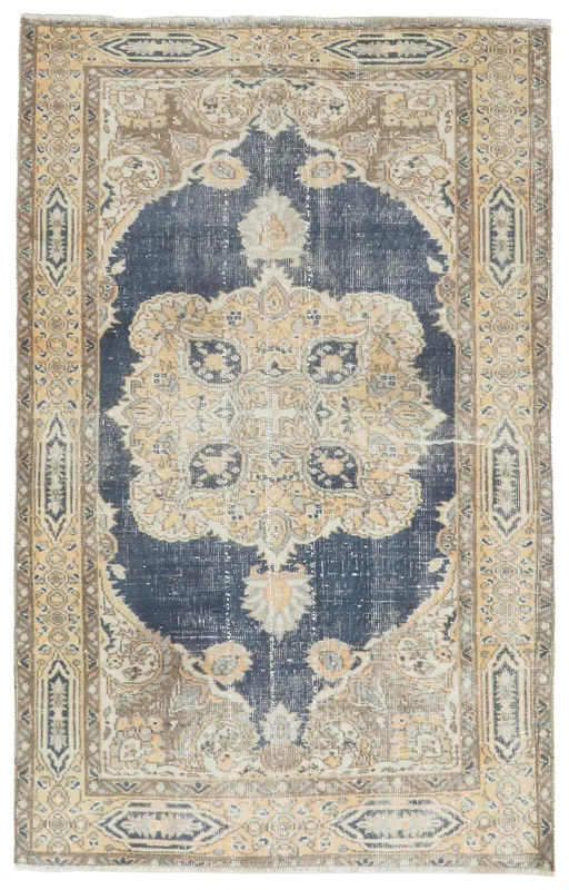 Full overhead view of the navy and tan vintage Anatolian rug on a white background