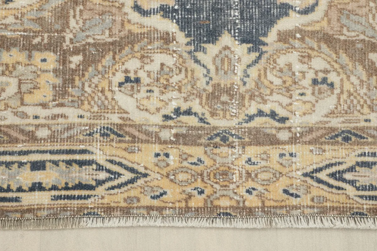 Close-up of the short fringe and the intricate border pattern at the rug's end