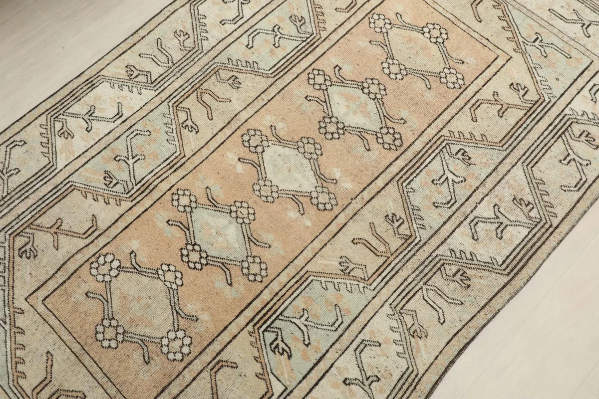 Overhead angled view showing the central rose field and surrounding beige border of the rug