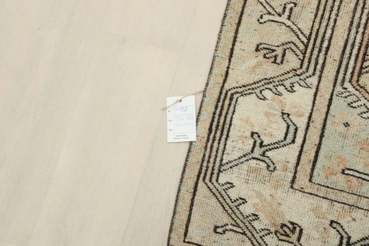 Overhead view of a small section of the rug with a label, showing its texture and colors