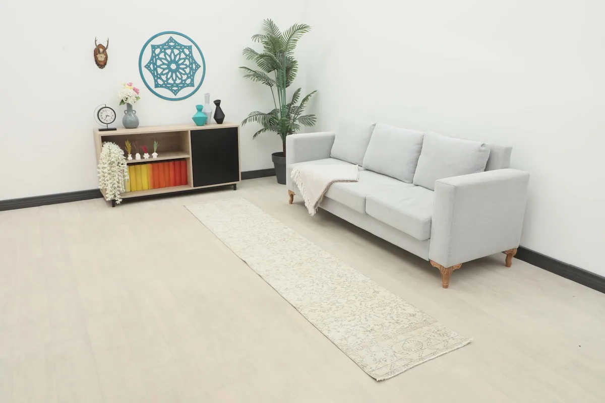 Vintage runner rug in a room setting, extending from a modern sofa towards a console table