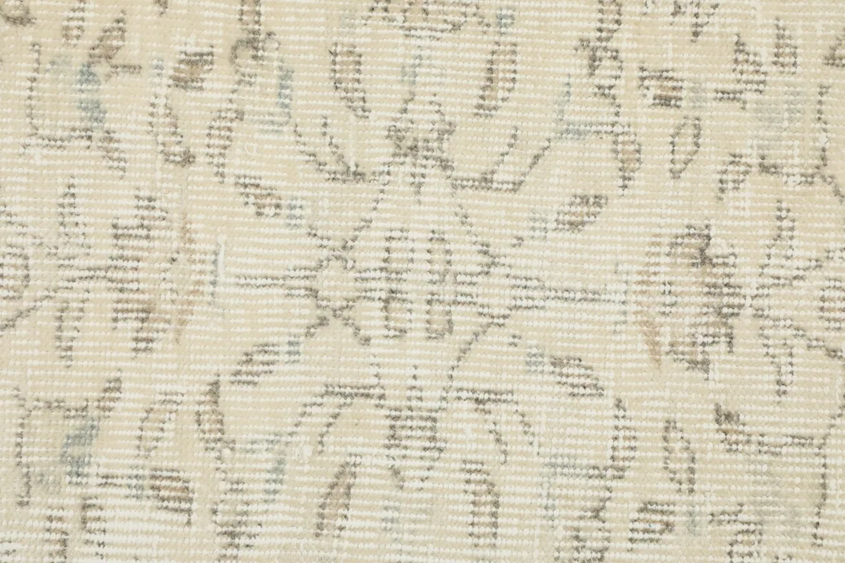 Extreme close-up of the rug pile, revealing the hand-knotted texture and faded gray patterns