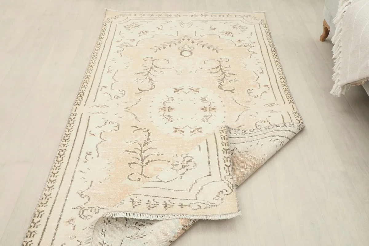 Rug partially folded, displaying the full length and the flexibility of the vintage textile