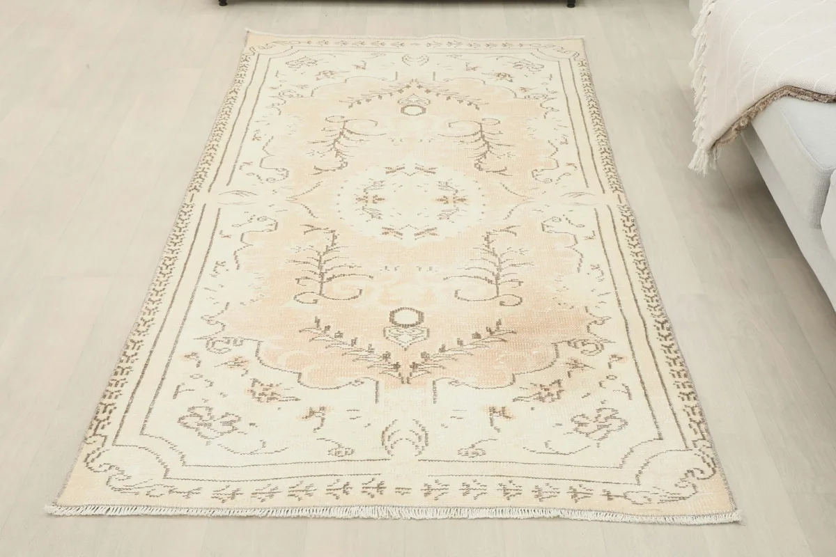 Full overhead view of the beige and rose Anatolian rug placed in a room setting