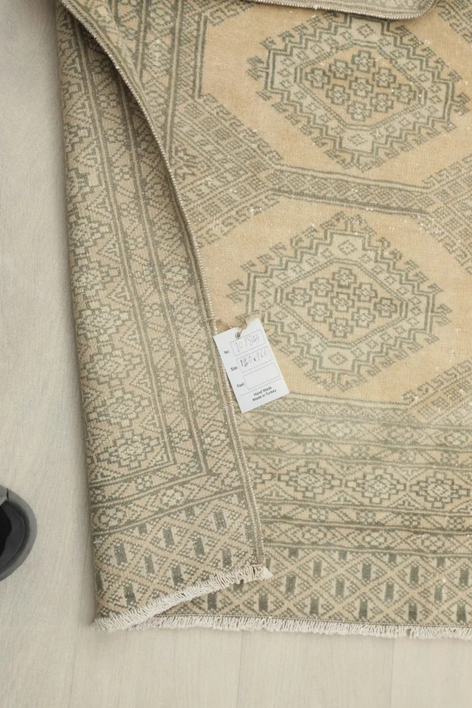 Close-up of the rug's label and the reverse side, showing the hand-knotted construction.