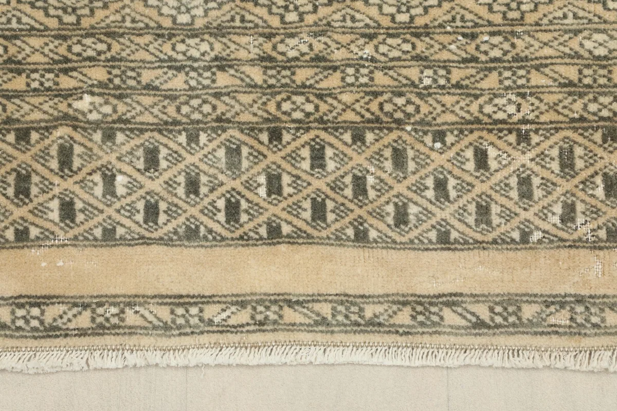 Close-up of the rug's border and fringe, showing the hand-knotted wool texture.