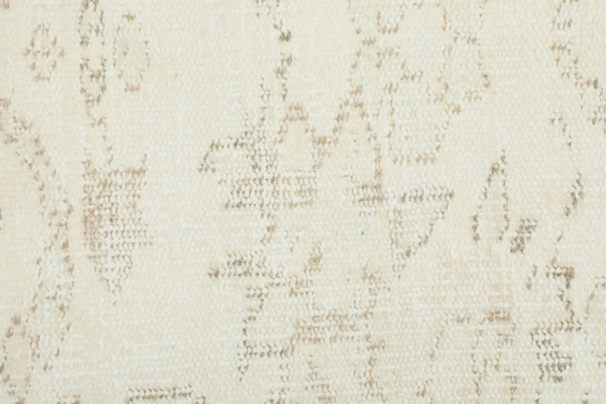 Detailed close-up of the rug's pile, revealing the hand-knotted texture and the distressed geometric design.