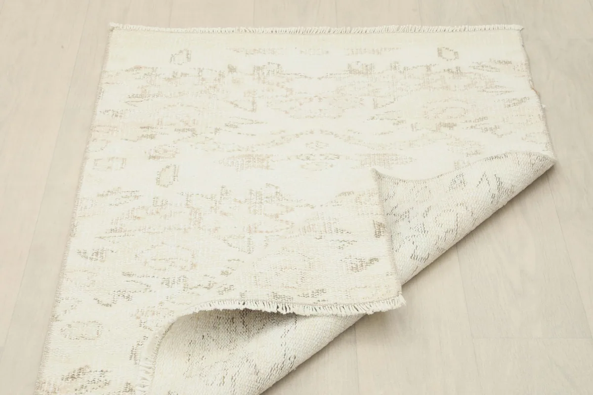 Rug partially folded, displaying both the front and a glimpse of the back, confirming its construction.