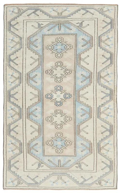 Full overhead view of the beige and blue geometric Anatolian area rug on a white background