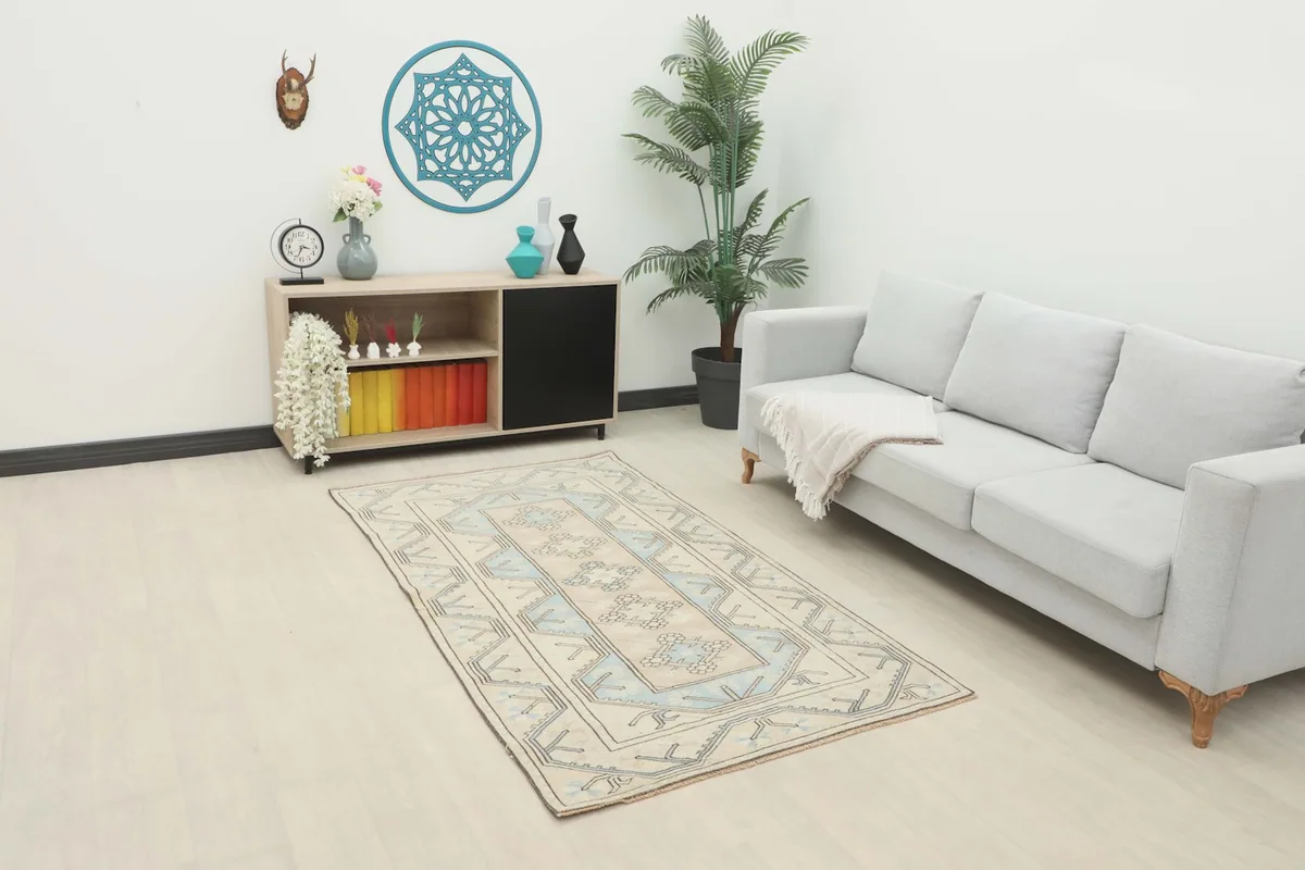 Vintage beige and blue rug in a living room setting with a light gray sofa and modern decor
