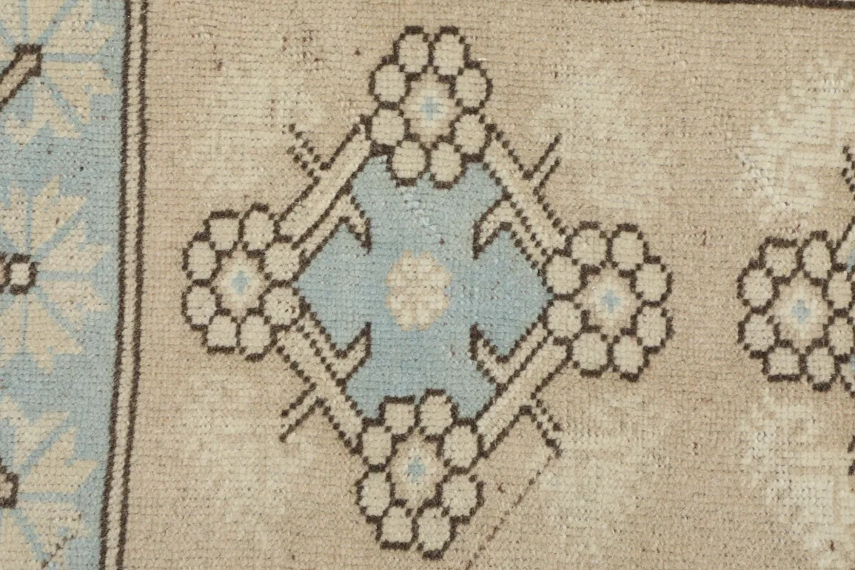 Detailed view of a central blue and beige geometric motif with a stylized floral outline
