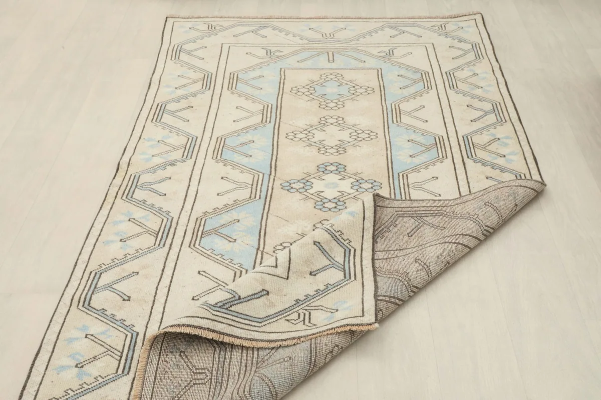 Rug partially folded, displaying both the pile side and the sturdy cotton foundation