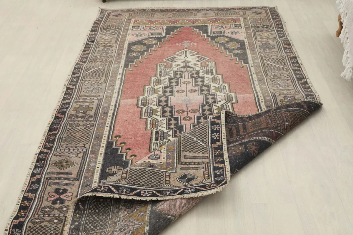 Rug partially folded, showing the thickness and construction from the side.