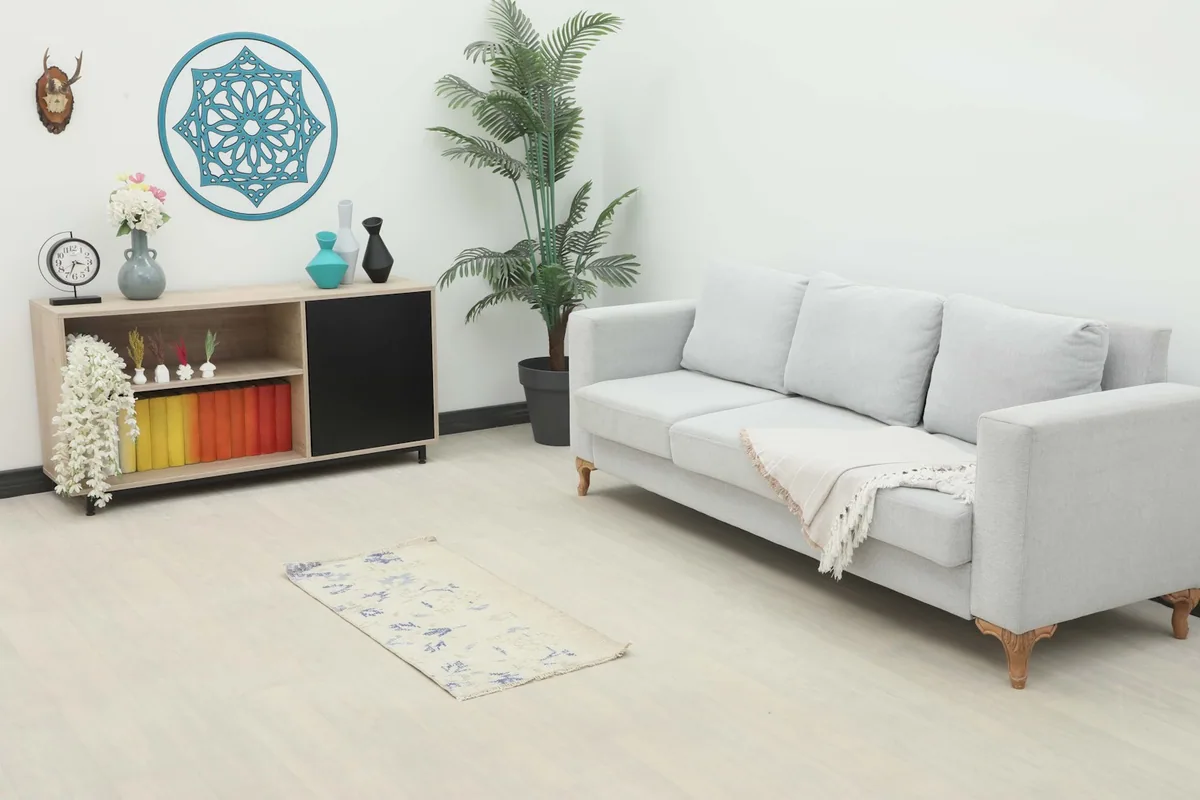Ivory and blue vintage rug placed in a living room setting, complementing a light gray sofa and modern decor.
