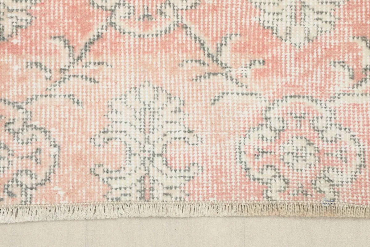 Close-up showing the short, natural fringe and edge of the vintage rug