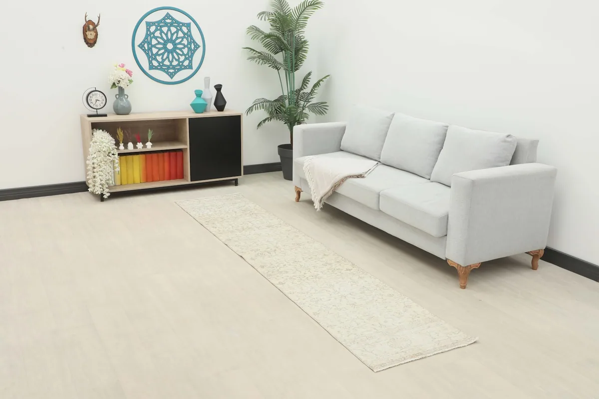Ivory vintage runner placed in a modern living room setting, extending from a sofa.
