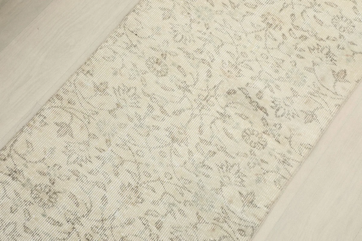 Overhead close-up of the central field of the runner, highlighting the faded floral motifs.