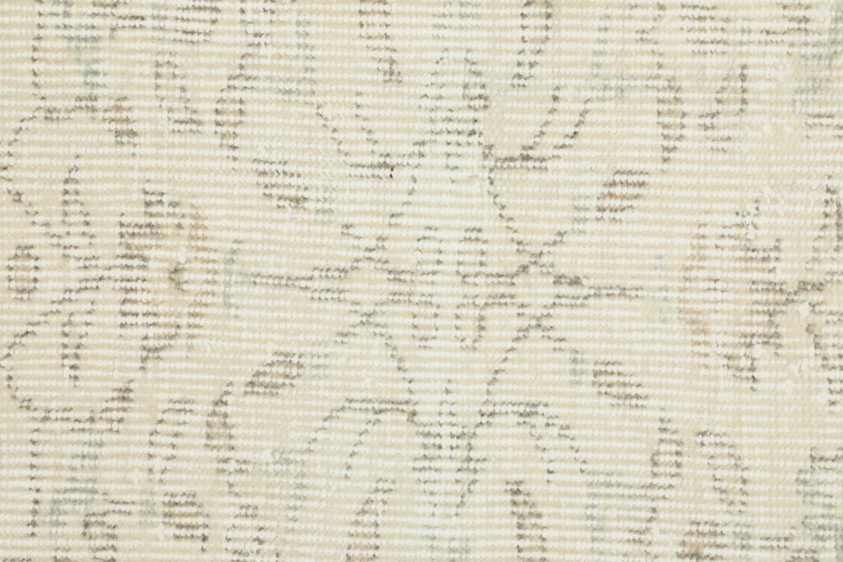 Extreme close-up of the wool pile texture and intricate, faded geometric patterns.