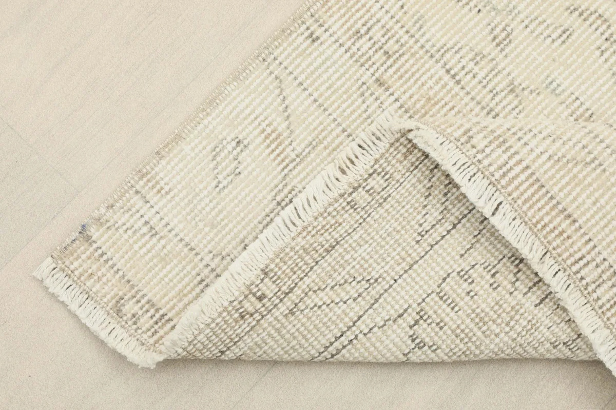 Corner of the runner folded back, revealing the cotton foundation and the reverse side.